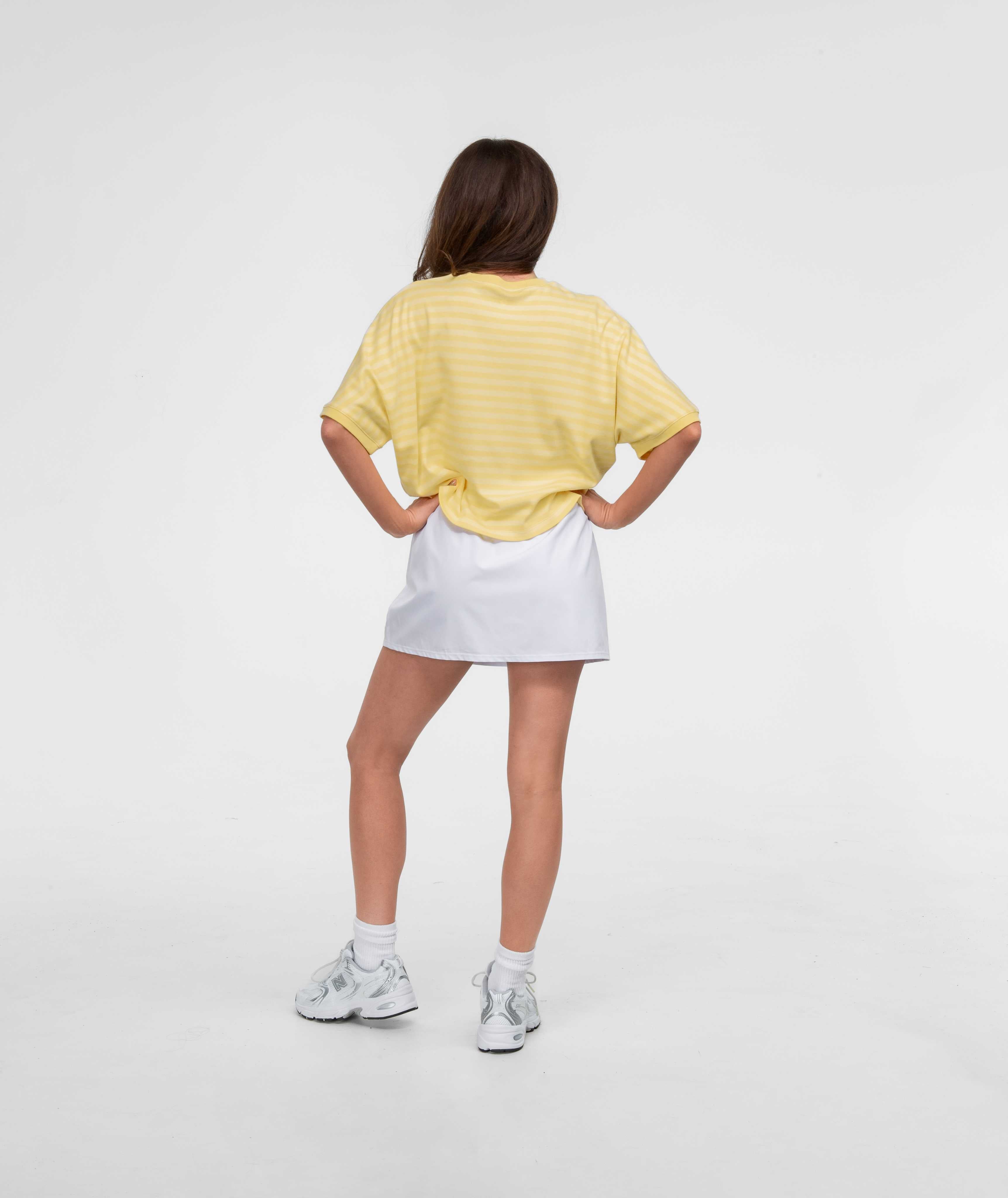 On The Line SS Top displayed on a model, showcasing the yellow striped design from the back.