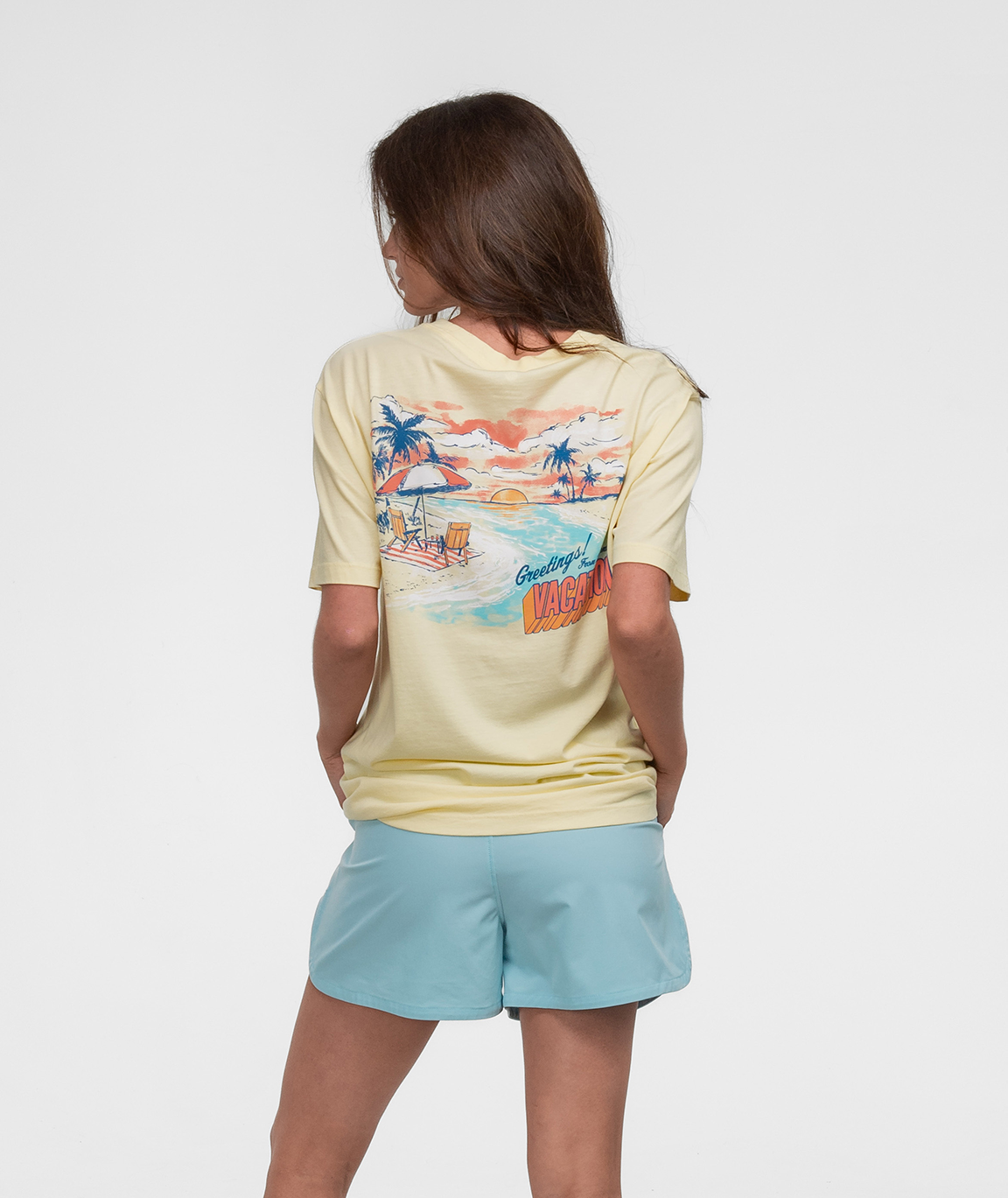 Girl wearing the Mental Vacation Tee SS with a tropical design on the back in a relaxed pose.