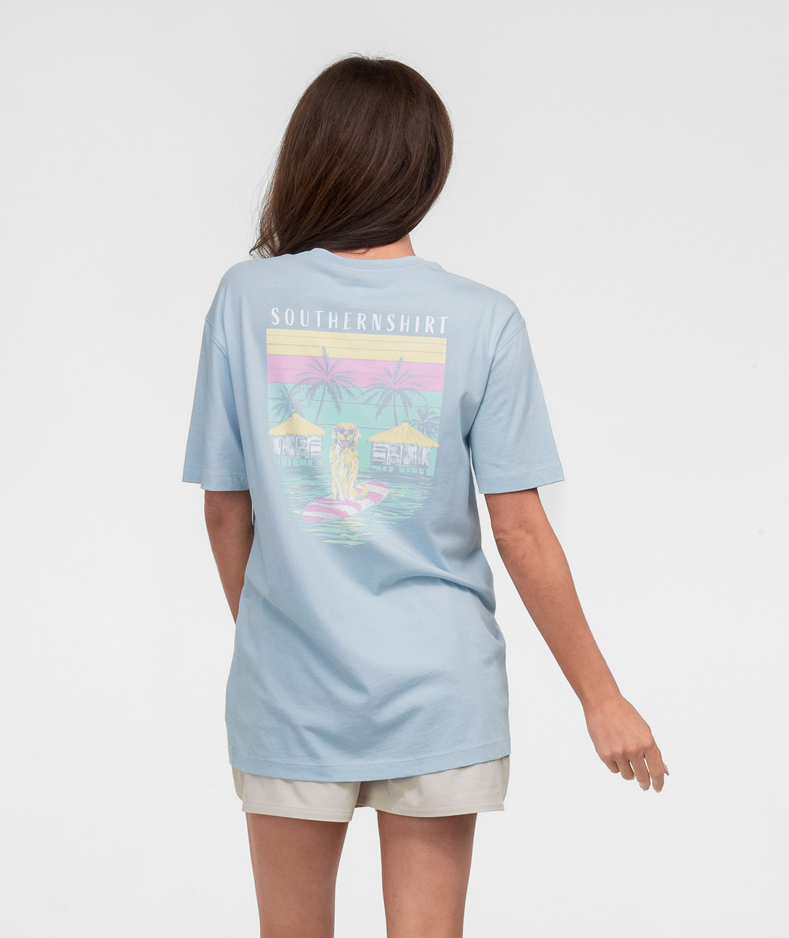 Woman wearing the No Ruff Waters Tee SS from Southern Shirt, showcasing a vibrant beach graphic on the back.